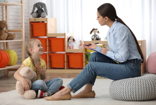 Psicoterapeuta infantil trabajando con una niña en el consultorio —  Fotos de Stock