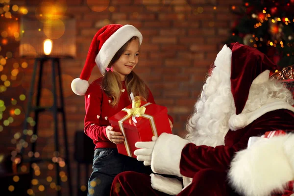 Papá Noel dando regalo de Navidad a la niña en el interior —  Fotos de Stock