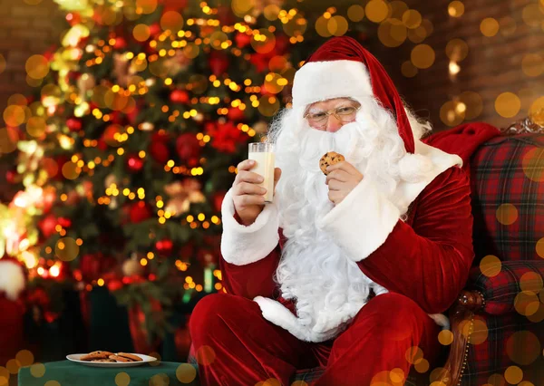Père Noël avec lait et biscuits près de l'arbre de Noël à l'intérieur — Photo