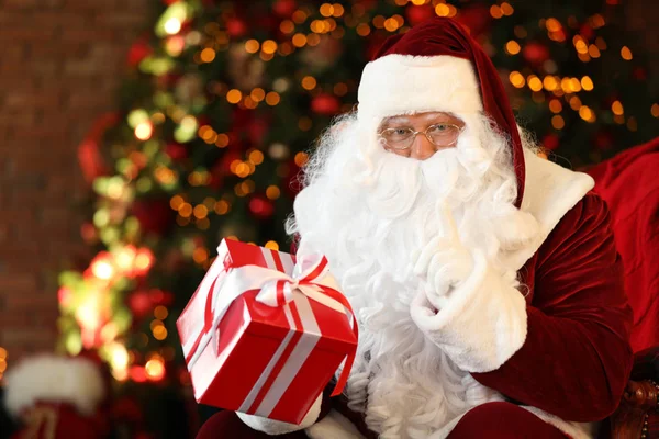 Père Noël avec boîte cadeau près de l'arbre de Noël à l'intérieur — Photo