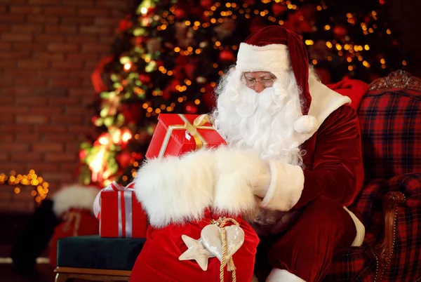 Weihnachtsmann Mit Geschenksack Neben Weihnachtsbaum Drinnen — Stockfoto