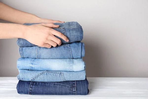 Mulher Jeans Elegante Dobrável Sobre Mesa Madeira Branca Close Espaço — Fotografia de Stock