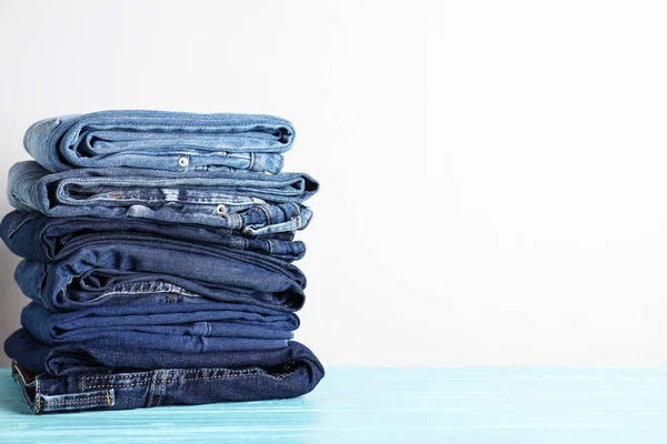 Stapel Verschillende Jeans Blauwe Houten Tafel Ruimte Voor Tekst — Stockfoto