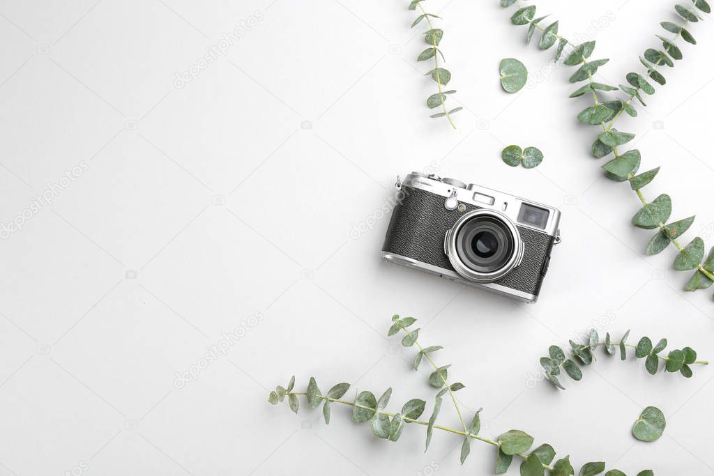 Flat lay composition with camera for professional photographer on light background, top view