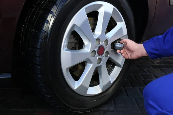 정비사 봉사를 하다가 타이어의 기압을 확인하는 클로즈업 — 스톡 사진