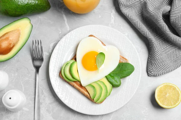 Smaklig frukost med hjärtformade stekta ägg serveras på grå tabl — Stockfoto