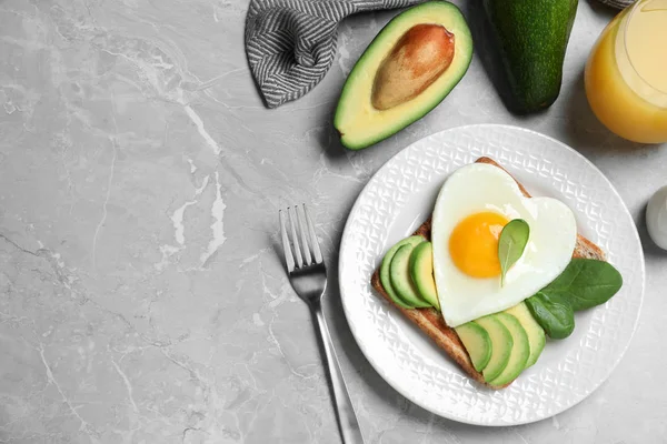 회색 식탁에서는 하트 모양의 튀긴 계란 과 함께 맛있는 아침 식사가 제공 된다 — 스톡 사진