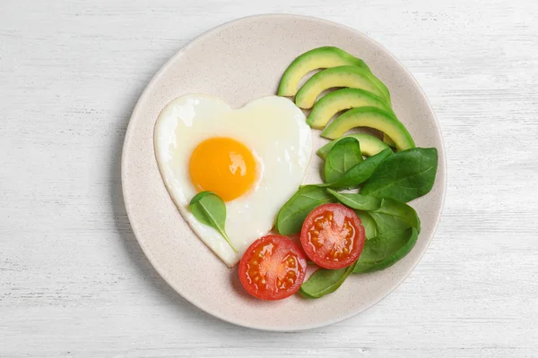 하얀 우위에 하트 모양의 튀긴 달걀을 얹은 맛있는 아침 식사 접시 — 스톡 사진