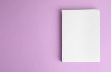 Menekşe arka planında boş kapaklı kitap, üst görünüm. Metin için boşluk