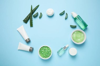 Farklı kozmetik ürünleri ve açık mavi arkaplan üzerinde aloe düz kompozisyon, metin için boşluk