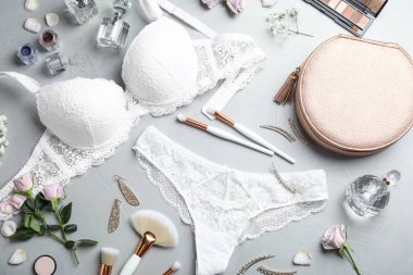 Açık gri arka planda zarif kadın iç çamaşırlarıyla düz bir kompozisyon vardı.