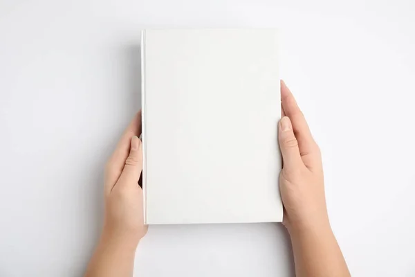 Γυναίκα Κρατώντας Βιβλίο Κενό Εξώφυλλο Λευκό Φόντο Πάνω Όψη — Φωτογραφία Αρχείου
