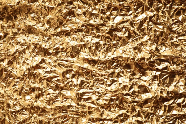Zgnieciona folia złota jako tło, widok z góry — Zdjęcie stockowe