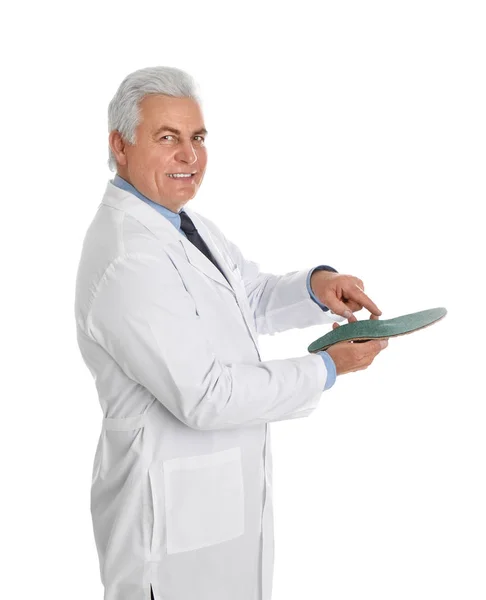 Ortopedista masculino mostrando plantilla sobre fondo blanco —  Fotos de Stock