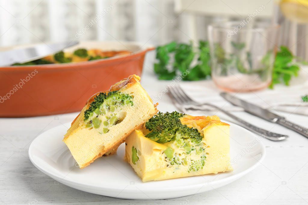 Tasty broccoli casserole served on white wooden table