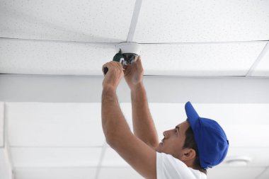 teknisyen kapalı tavan üzerine kapalı devre kamera kuruyor