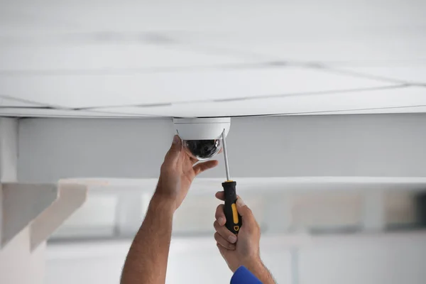 Techniker installiert Videokamera an der Decke drinnen, Nahaufnahme — Stockfoto