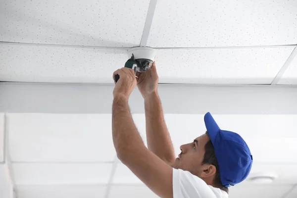 室内の天井にccTVカメラを設置する技術者 — ストック写真