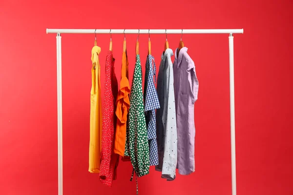 Roupas Brilhantes Penduradas Rack Contra Fundo Vermelho Cores Arco Íris — Fotografia de Stock