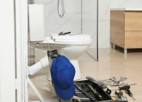 Ferramentas de encanador perto de vaso sanitário no banheiro — Fotografia de Stock
