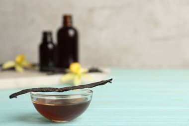 Açık mavi ahşap masada ev yapımı vanilya özü. Metin için boşluk