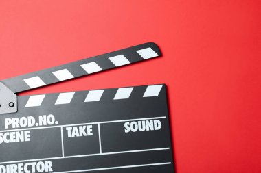 Kırmızı arkaplanda el çırpma tahtası, üst görünümde. Sinema yapımı