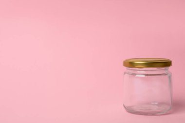 Pembe arkaplanda boş cam kavanoz, metin için boşluk