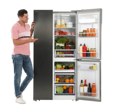 Buzdolabının yanındaki adam beyaz arkaplanda.