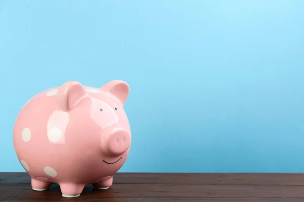 Banco Piggy Rosa Mesa Madeira Contra Fundo Azul Claro Espaço — Fotografia de Stock