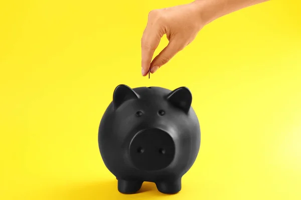 Frau Steckt Münze Sparschwein Auf Gelbem Hintergrund Nahaufnahme — Stockfoto