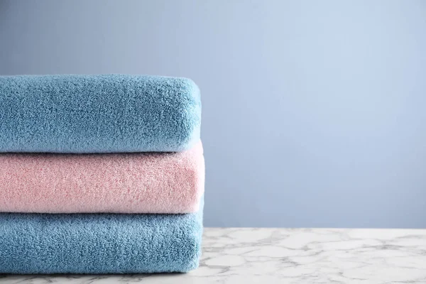 Montón de toallas de baño limpias en la mesa de mármol blanco. Espacio para texto — Foto de Stock