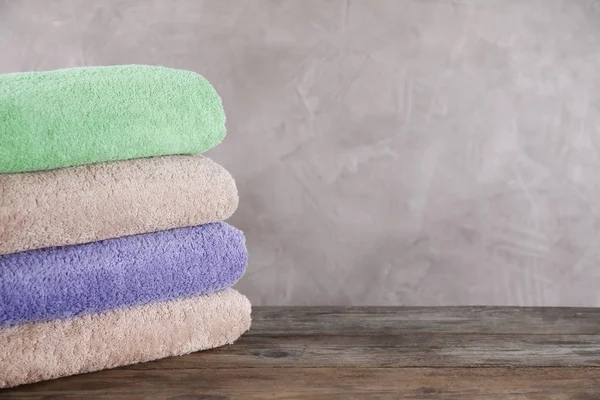 Stack of clean bath towels on wooden table. Space for text — Stock Photo, Image