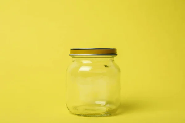 Frasco de vidro vazio fechado no fundo amarelo claro — Fotografia de Stock