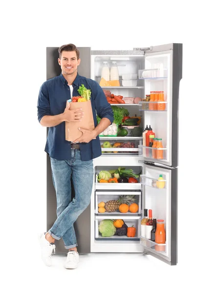 Muž Taškou Potravin Blízkosti Otevřené Chladničky Bílém Pozadí — Stock fotografie