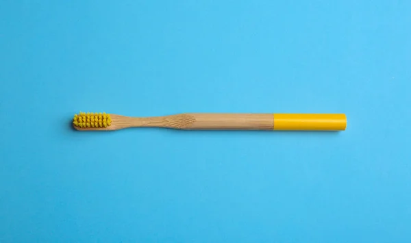 Toothbrush made of bamboo on light blue background, top view — Stock Photo, Image