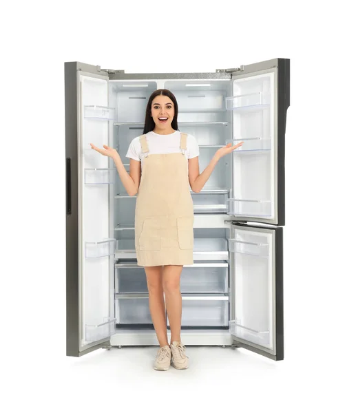 Νεαρή Γυναίκα Κοντά Άδειο Ψυγείο Λευκό Φόντο — Φωτογραφία Αρχείου