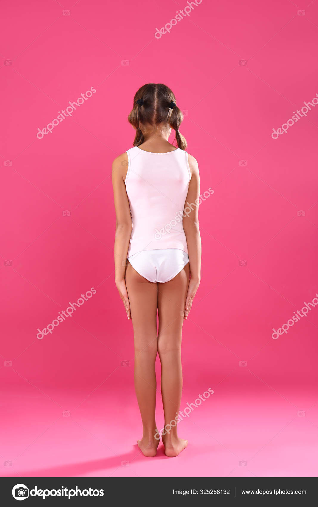 Little girl in underwear on pink background, back view Stock Photo