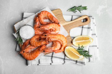Gri mermer masada limon ve tuzla servis edilen lezzetli pişmiş karidesler.