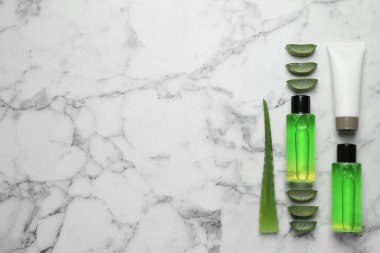 Beyaz mermer zemin üzerinde aloe vera ve kozmetik ürünler ile düz bileşim yatıyordu. Metin için boşluk