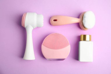 Menekşe sırt üzerinde yüz temizleyici fırçalar ile düz kompozisyon yatıyordu