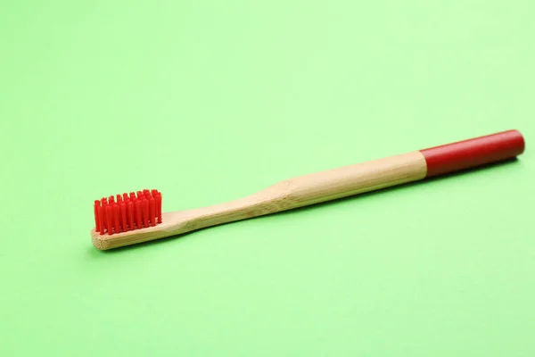 Naturalna bambusowa szczoteczka do zębów z miękkimi włosami na zielonym tle — Zdjęcie stockowe