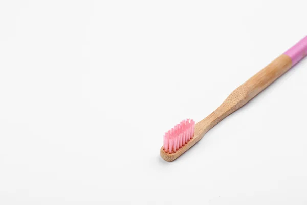 Escova de dentes de bambu com cerda rosa isolada em branco — Fotografia de Stock