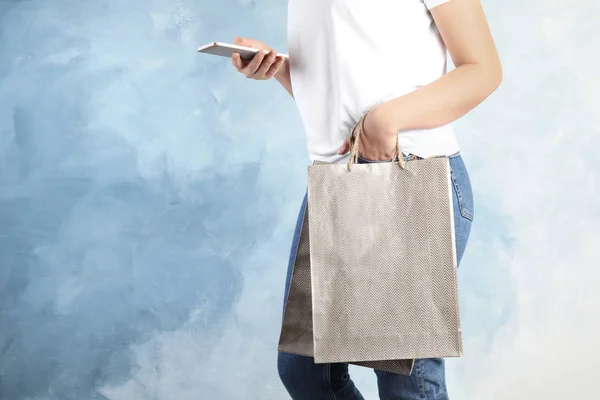 Γυναίκα Ασημένια Τσάντες Shopping Χαρτί Και Smartphone Γαλάζιο Φόντο Closeup — Φωτογραφία Αρχείου