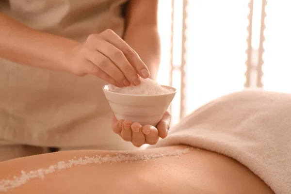 Jovem mulher tendo procedimento de limpeza corporal com sal marinho no spa — Fotografia de Stock