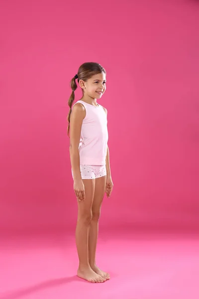 Niedliches kleines Mädchen in Unterwäsche auf rosa Hintergrund — Stockfoto