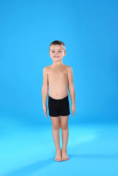 Niedlicher kleiner Junge in Unterwäsche auf hellblauem Hintergrund — Stockfoto
