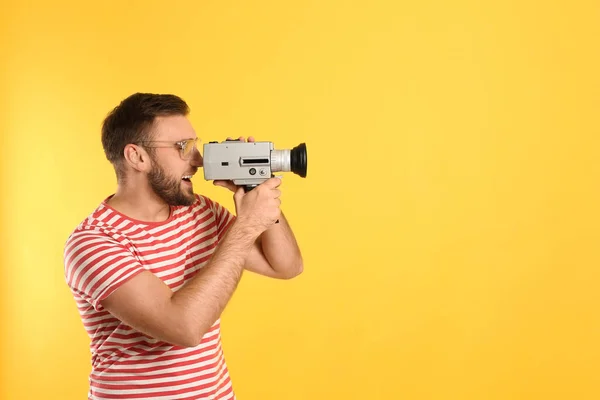 Jongeman Met Vintage Videocamera Gele Achtergrond Ruimte Voor Tekst — Stockfoto