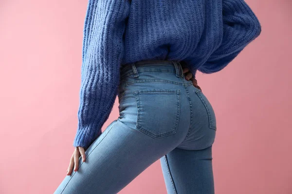 Vrouw in jeans op roze achtergrond, close-up — Stockfoto