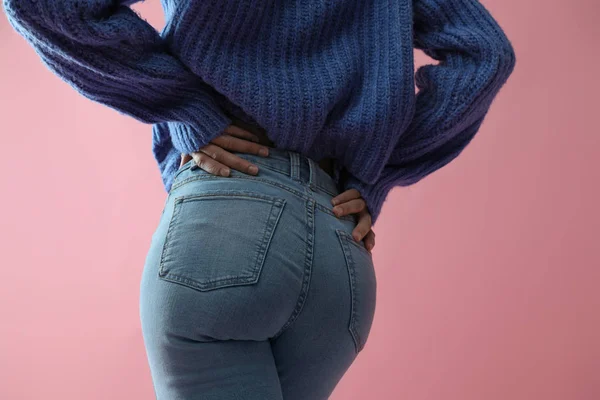 Žena v džínách na růžovém pozadí, detailní záběr — Stock fotografie