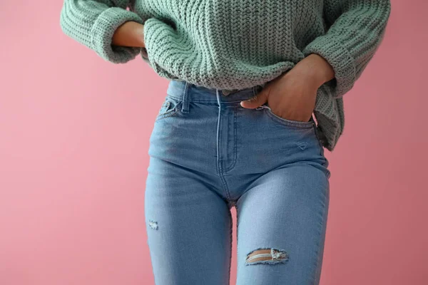 Vrouw in jeans op roze achtergrond, close-up — Stockfoto
